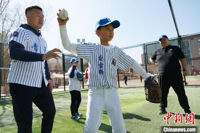 圖為教練指導(dǎo)小棒球手?jǐn)S球技術(shù)。　馬銘言 攝