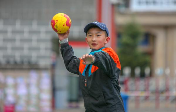 在高原上教孩子們打手球，“慢慢兒來(lái)，甭著急！”