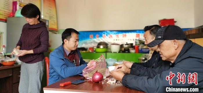 圖為扶貧路上“臨時一家人”準(zhǔn)備午餐?！∥航ㄜ?攝