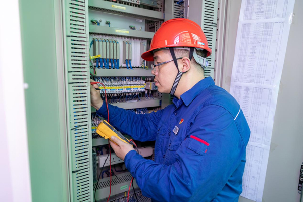 呂曉勇在保護(hù)盤柜前檢查二次回路接線情況。受訪者供圖