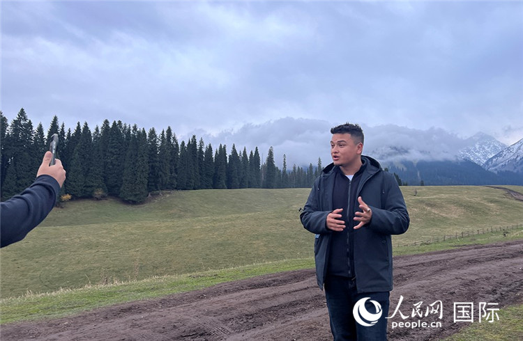 在庫(kù)爾德寧，吾買爾江被雪山美景震撼，即興錄制了短視頻作品。人民網(wǎng)記者曾書柔攝