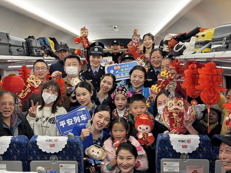 春節(jié)期間，在中老鐵路磨萬（磨丁—萬象）段，鐵路客運員工與乘客合影留念。李加勇攝