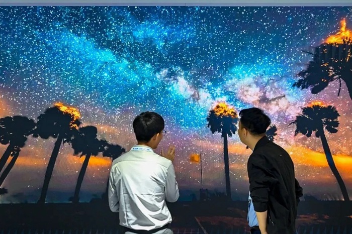 長春光博會希達(dá)電子展區(qū)，一位工作人員正在給一位觀眾講解。（長春新區(qū)供圖）