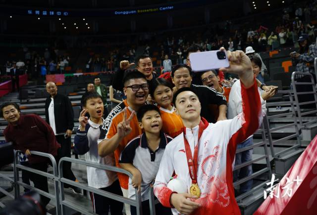 11月12日，十五運(yùn)會(huì)男籃成年組決賽，廣東隊(duì)獲得冠軍后，胡明軒與球迷們合影留念。張由瓊 攝