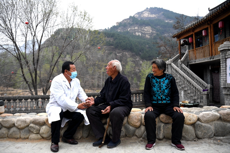 2020年4月15日，在河北阜平縣龍泉關(guān)鎮(zhèn)駱駝灣村，村醫(yī)霍建國為村民把脈。