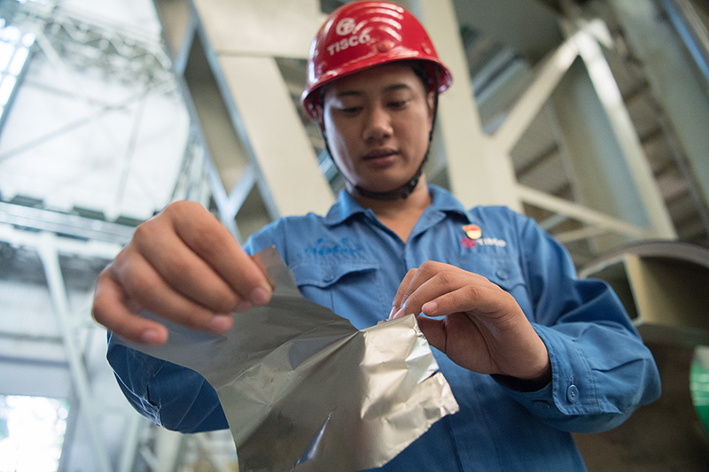 2018年8月8日，山西省太原市，太鋼精密帶鋼公司工作人員用手撕開不銹鋼。