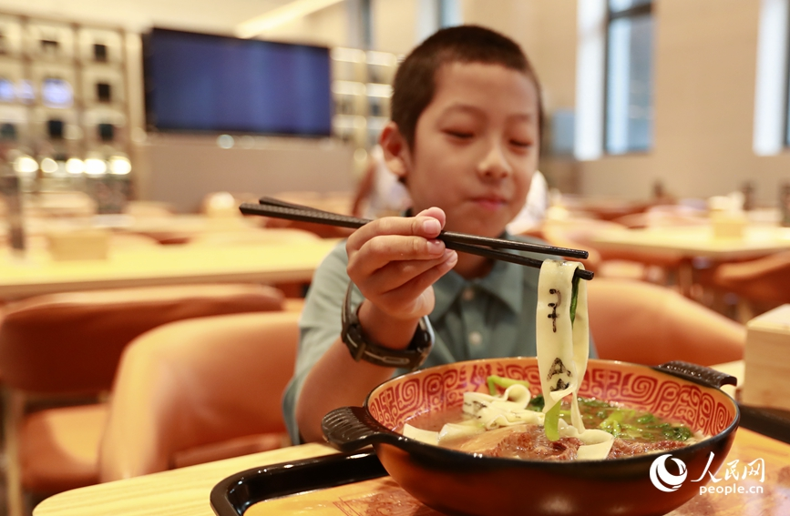 殷墟博物館推出的甲骨文面深受游客喜愛。人民網(wǎng)記者 慎志遠(yuǎn) 攝