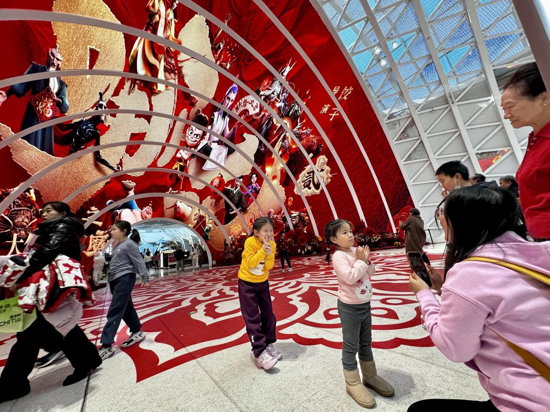 乙巳蛇年春節(jié)期間，影迷在《哪吒之魔童鬧海》巨幅海報前拍照打卡。