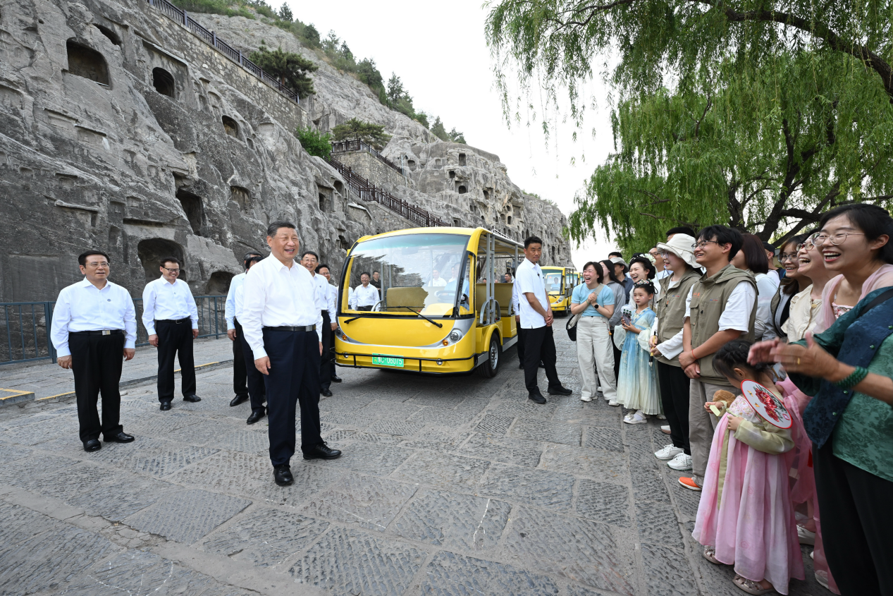 5月19日，習近平在洛陽龍門石窟考察時，同游客親切交流。