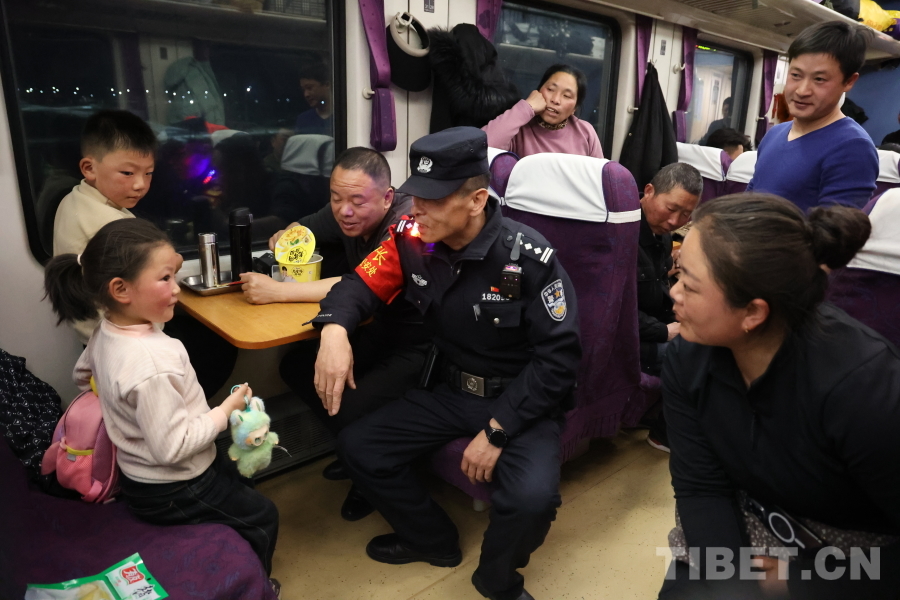 乘警長左紅彬在巡視車廂間隙，向攜帶兒童的旅客專門叮囑安全注意事項。.JPG
