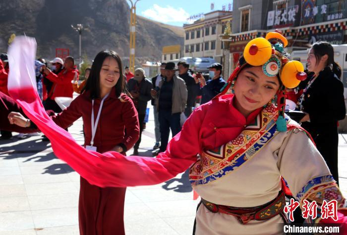 圖為中外記者向當(dāng)?shù)孛癖妼W(xué)習(xí)民族歌舞文化?！?zhí)砀?攝