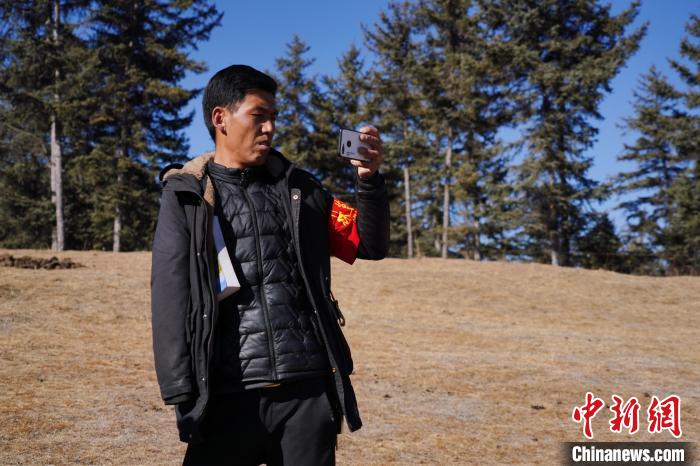 圖為桑杰加進(jìn)行巡查并拍照記錄?！●R銘言 攝