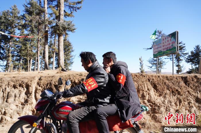 圖為同事騎摩托車載著桑杰加(后)前往林場(chǎng)?！●R銘言 攝