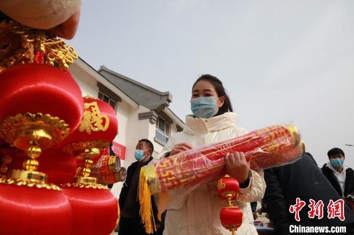 27日，蘭州新區(qū)為舟曲避險搬遷移民送“春節(jié)包”，楊周馬草前往領(lǐng)取，紅色寓意來年的日子紅紅火火?！∥航ㄜ?攝