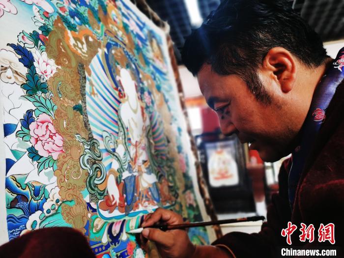 圖為久美尖措創(chuàng)作唐卡?！?zhí)砀?攝