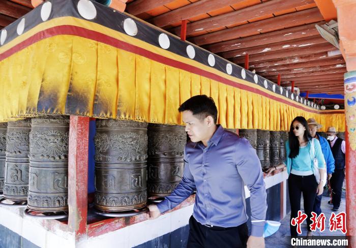 圖為外籍嘉賓體驗(yàn)藏族傳統(tǒng)轉(zhuǎn)經(jīng)筒。　馬銘言 攝