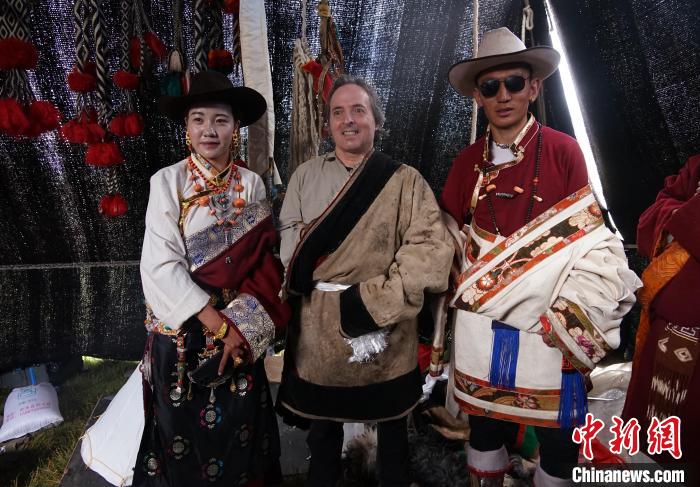 圖為一名外籍?dāng)z影師(中)身穿藏服和藏族民眾合影留念。　馬銘言 攝