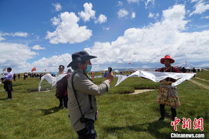 圖為一名外籍?dāng)z影師記錄當(dāng)?shù)夭刈鍤g迎儀式?！●R銘言 攝