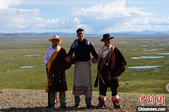 圖為一名留學(xué)生身穿自己國(guó)家的服飾和藏族民眾合影留念?！●R銘言 攝