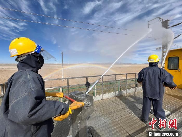 圖為水炮手操作高壓水槍對(duì)絕緣子進(jìn)行清洗。　高啟宏 攝