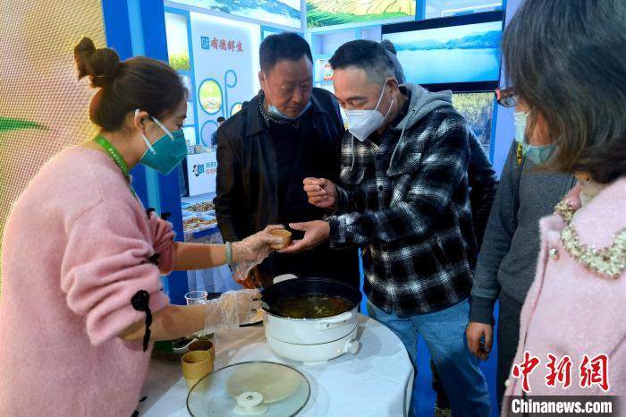 圖為杭州市民品嘗茶卡羊肉。　李雋 攝