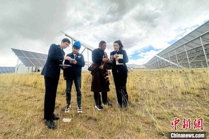 圖為稅務(wù)干部上門開展稅費輔導(dǎo)?！》劫F龍 攝