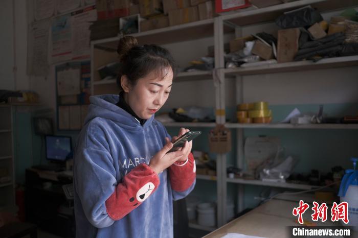 正在快遞站點內(nèi)忙碌的楊莉春?！『闻罾?攝