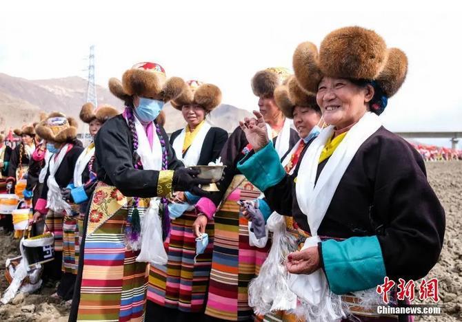 資料圖：西藏自治區(qū)拉薩市曲水縣才納鄉(xiāng)協(xié)榮村參加春耕儀式的村民互敬青稞酒。按照傳統(tǒng)，當(dāng)?shù)卮迕裆碇?jié)日盛裝，舉行隆重的儀式，祈福一年的豐收。<a target='_blank' ><p  align=