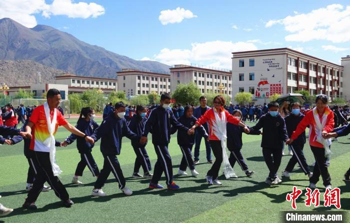 圖為世界冠軍與拉薩阿里地區(qū)高級中學學生一起跳鍋莊?！∪轿木?攝