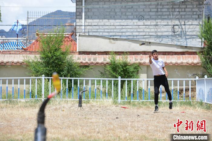 圖為西藏自治區(qū)拉薩市賽馬場(chǎng)內(nèi)市民在體驗(yàn)“打牛角”項(xiàng)目?！∝暩聛硭?攝