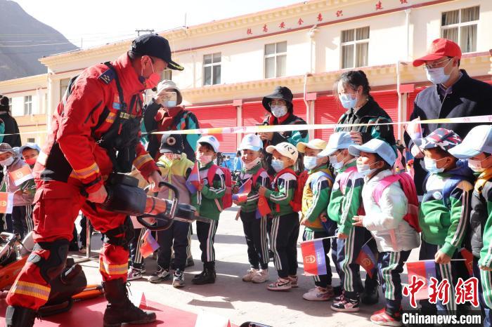 圖為消防指戰(zhàn)員為學(xué)生講解、演示先進救援裝備。　趙琳 攝