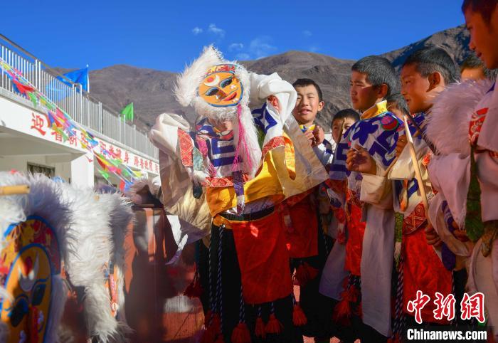 圖為加查縣安繞鎮(zhèn)小學(xué)學(xué)生在試穿藏戲面具?！∝暩聛?lái)松 攝