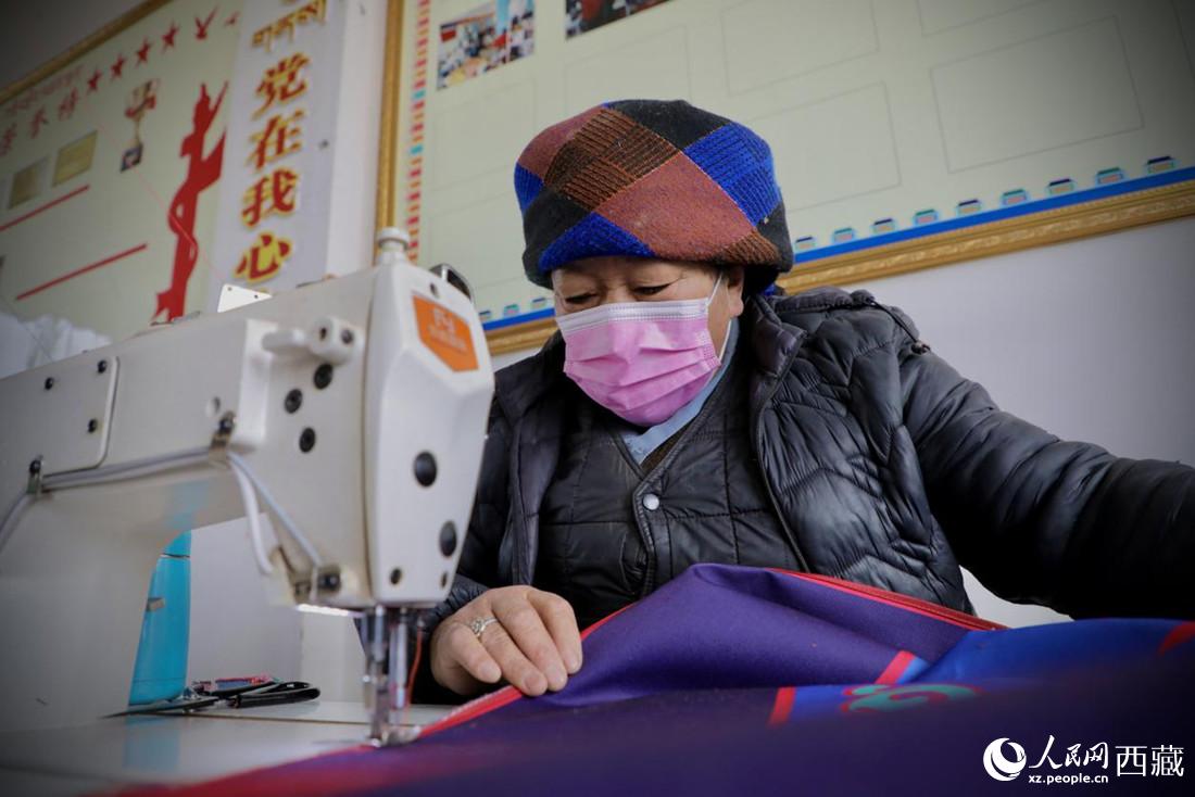 農(nóng)牧民專業(yè)合作社里的村民正在制作門簾。人民網(wǎng) 次仁羅布攝