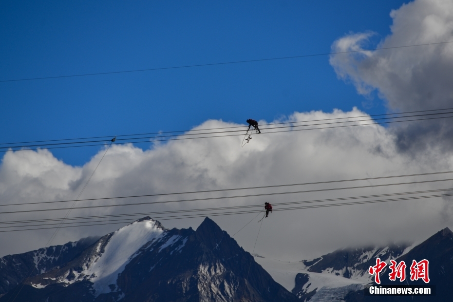 資料圖為2020年6月23日，西藏阿里聯(lián)網(wǎng)工程施工人員在日喀則希夏邦馬雪山附近進(jìn)行走線作業(yè)，安裝絕緣設(shè)備。 <a target='_blank' href='/'><p  align=