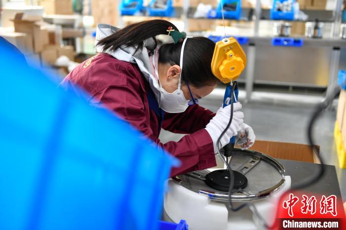 圖為工人正在組裝炊具。　貢嘎來(lái)松 攝