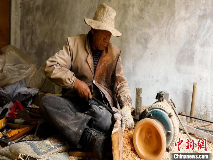 圖為手工藝人正在制作木碗?！?鄧海平 攝