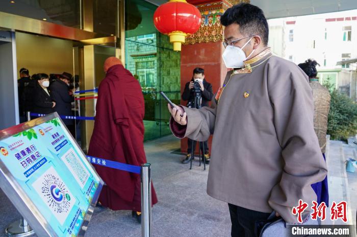 圖為政協(xié)委員掃場(chǎng)所碼進(jìn)入會(huì)場(chǎng)?！〗w波 攝