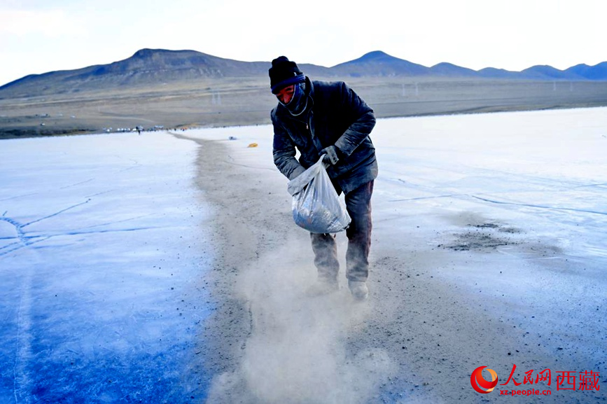 牧民在冰面上撒灰鋪成通道。人民網(wǎng) 李海霞攝