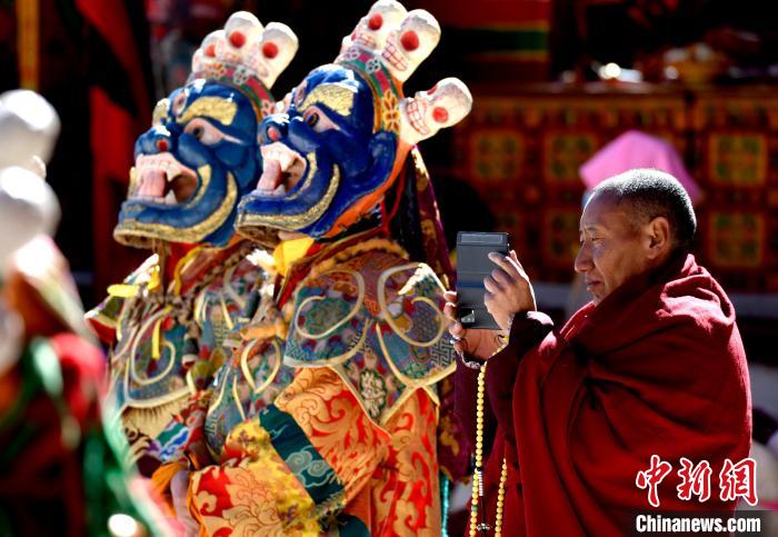 2月19日，正在拍攝跳神活動(dòng)的僧人?！±盍?攝