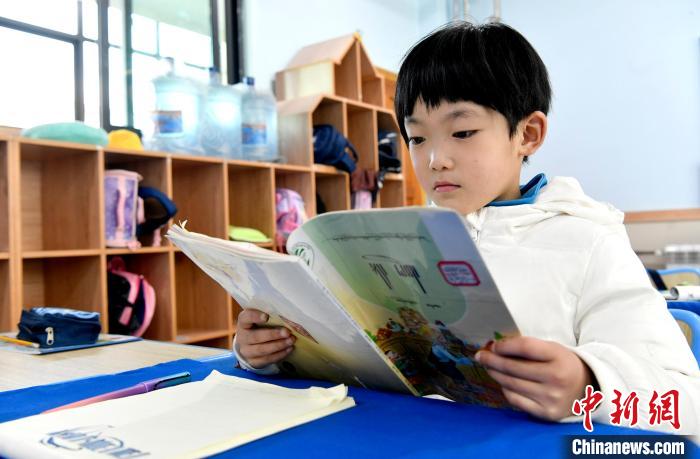 3月14日，西藏拉薩市第一小學(xué)一年級六班學(xué)生丁增樂吉在閱讀藏語課本?！±盍?攝