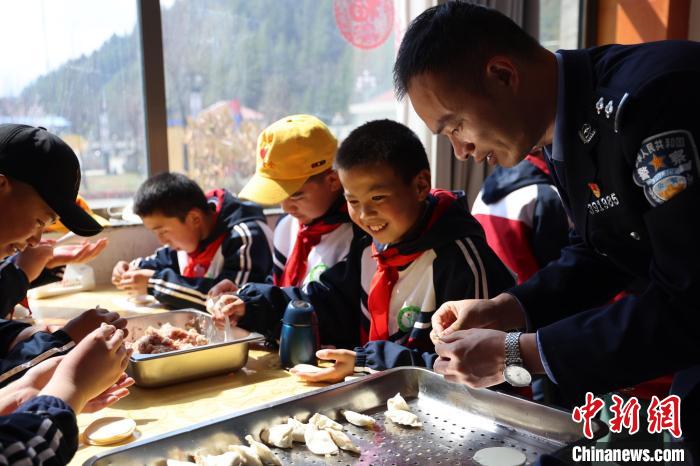 圖為亞東邊檢站民警與駐地小學(xué)生其樂融融包餃子。　胡利媛 攝