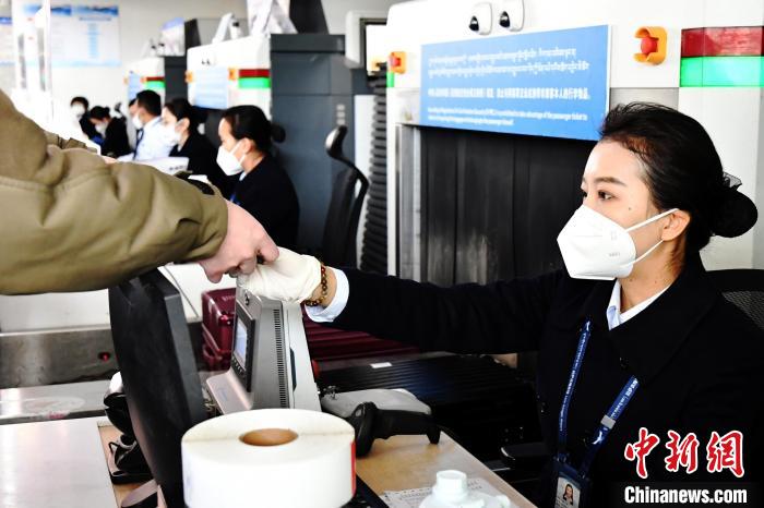 圖為機(jī)場(chǎng)工作人員為旅客辦理行李托運(yùn)?！≈芎?攝