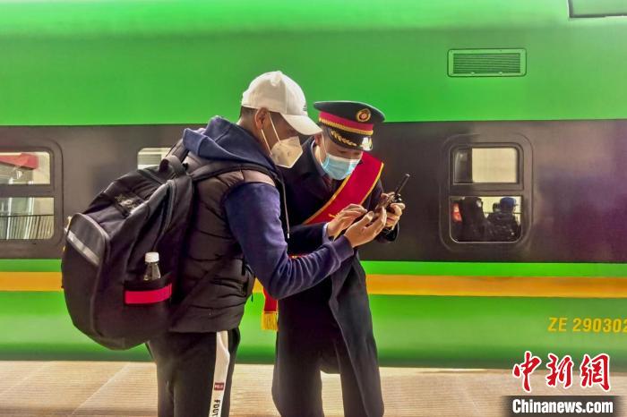 圖為日喀則火車站工作人員服務(wù)乘客?！《飞降?攝