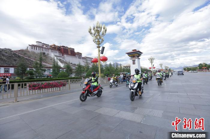 圖為比賽選手途經(jīng)布達拉宮?！∮文恋厍蚬﹫D
