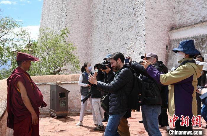 圖為中外媒體拍攝朝拜布達(dá)拉宮的僧人?！≮w朗 攝