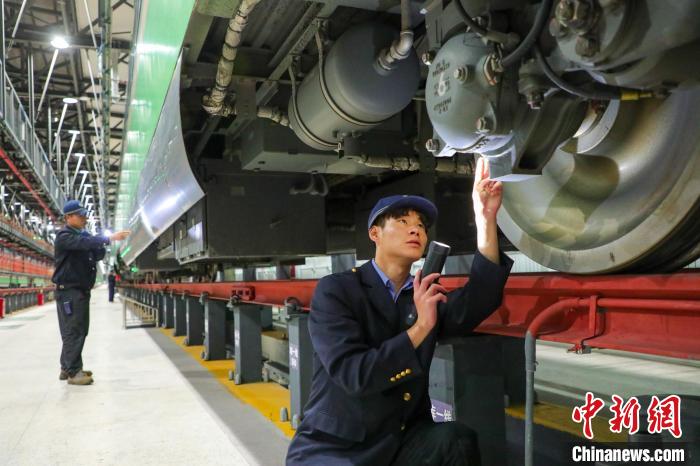 圖為工作人員檢查高原復(fù)興號?！≈軔傁?攝