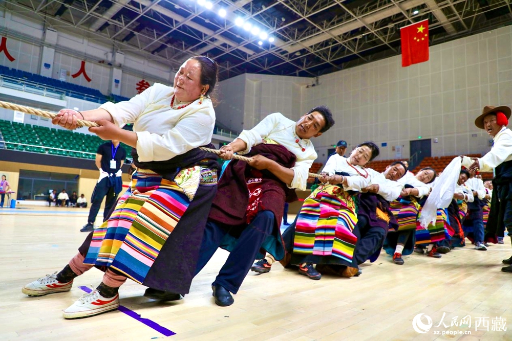 身著民族服裝的農(nóng)牧民選手在拔河比賽現(xiàn)場。