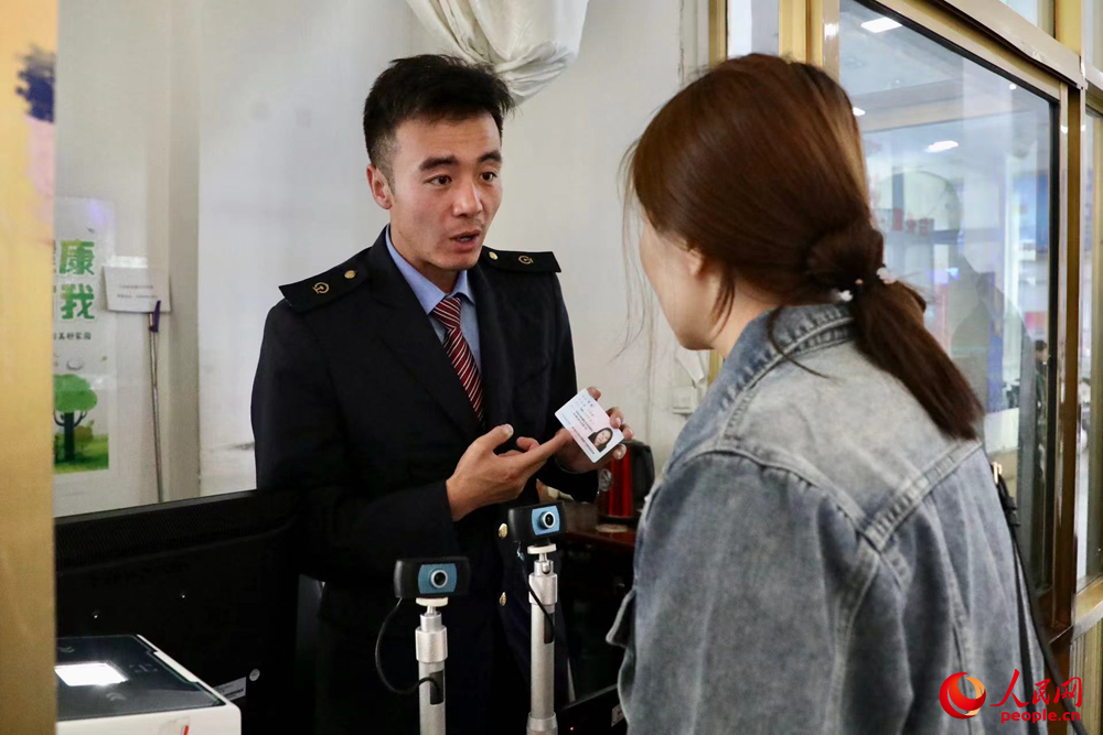 車站工作人員向旅客解答疑問(wèn)。人民網(wǎng)記者 次仁羅布攝