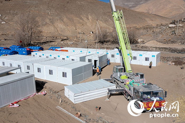 1月9日，在日喀則市定日縣長所鄉(xiāng)古榮村安置點(diǎn)，救援人員和施工人員合力抓緊搭建移動板房，確保受災(zāi)群眾溫暖過冬。人民網(wǎng)記者 翁奇羽攝
