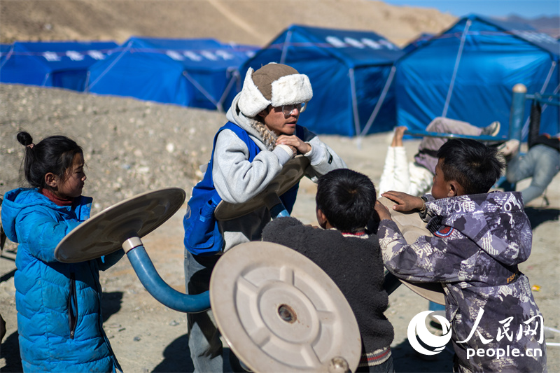 西藏星光社會(huì)工作服務(wù)中心社工久米旦增通過(guò)聊天談心，對(duì)孩子們進(jìn)行災(zāi)后心理疏導(dǎo)。人民網(wǎng)記者 翁奇羽攝